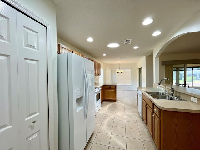15782 SW 16th Avenue Rd, Ocala, FL 34473 - kitchen with visible vents, a sink, arched walkways, white appliances, and brown cabinetry