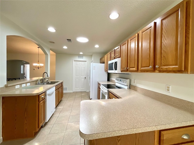 15782 SW 16th Avenue Rd, Ocala, FL 34473 - kitchen featuring arched walkways, a sink, visible vents, white appliances, and brown cabinets