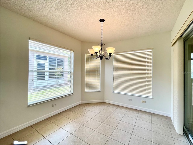 15782 SW 16th Avenue Rd, Ocala, FL 34473 - unfurnished dining area featuring baseboards, an inviting chandelier, a textured ceiling, and light tile patterned floors