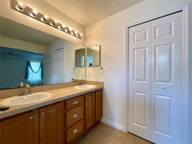 15782 SW 16th Avenue Rd, Ocala, FL 34473 - bathroom featuring double vanity, a textured ceiling, tile patterned flooring, and a sink