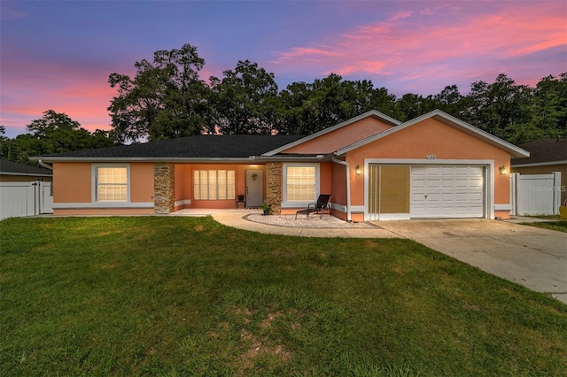 single story home with a garage, fence, driveway, and a yard