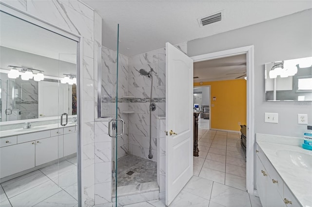 bathroom with a sink, marble finish floor, visible vents, and a marble finish shower