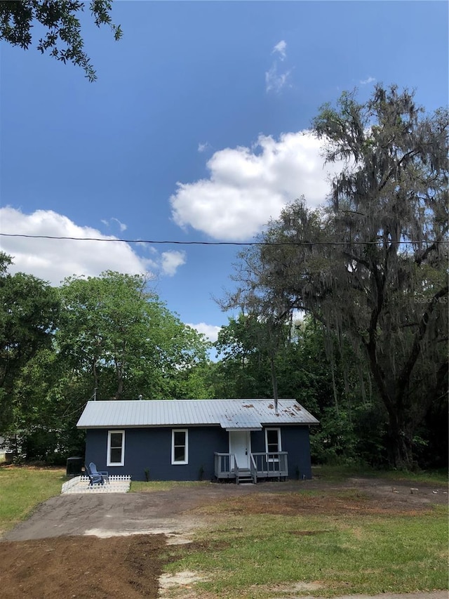 257 NE 8th St, Williston, FL 32696 - ranch-style house with a front lawn and metal roof