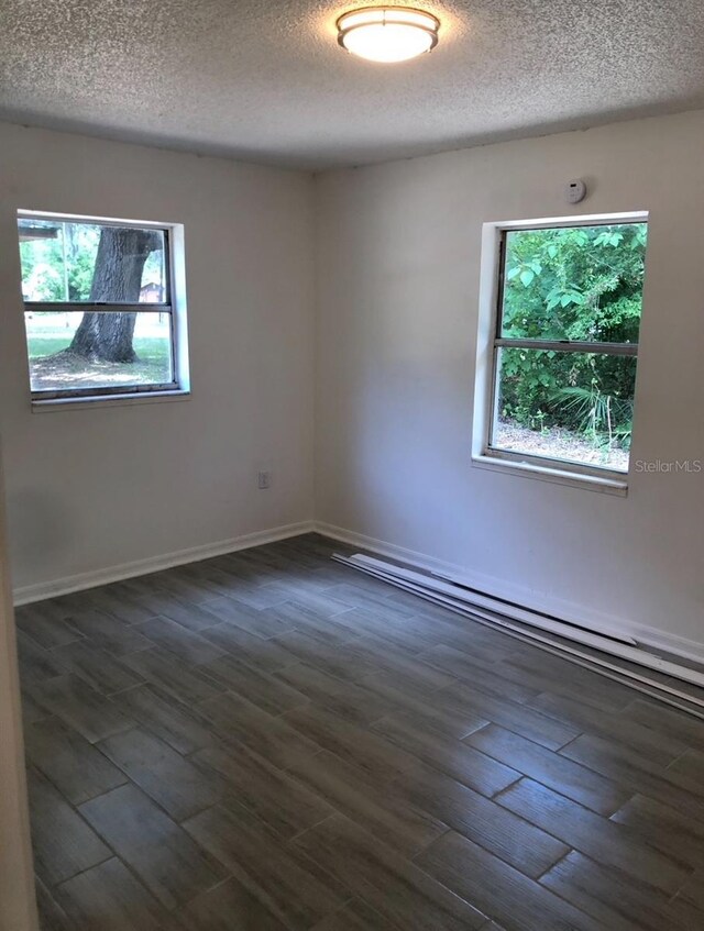 257 NE 8th St, Williston, FL 32696 - unfurnished room featuring a textured ceiling and dark wood-type flooring