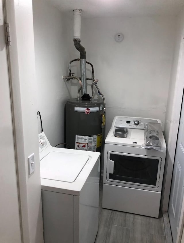 257 NE 8th St, Williston, FL 32696 - laundry room with washing machine and clothes dryer, water heater, light wood-style flooring, and laundry area