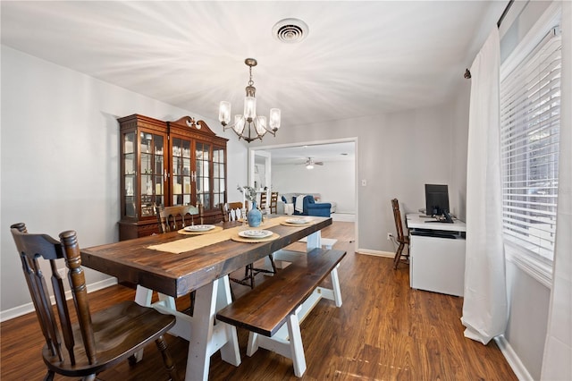 219 NW 7th St, Williston, FL 32696 - dining space featuring dark wood-style flooring, baseboards, visible vents, and ceiling fan with notable chandelier