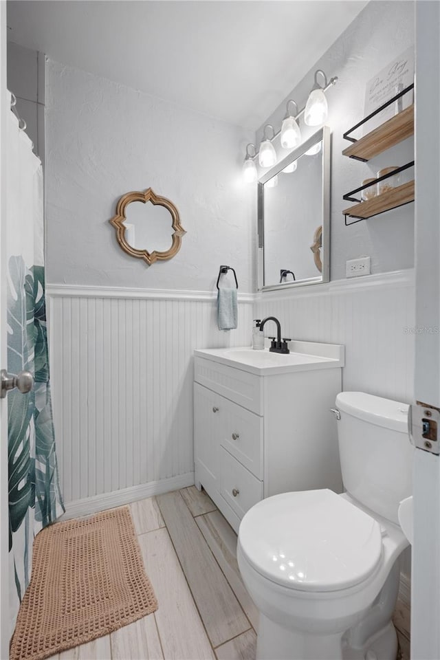 219 NW 7th St, Williston, FL 32696 - full bathroom with vanity, wainscoting, and toilet