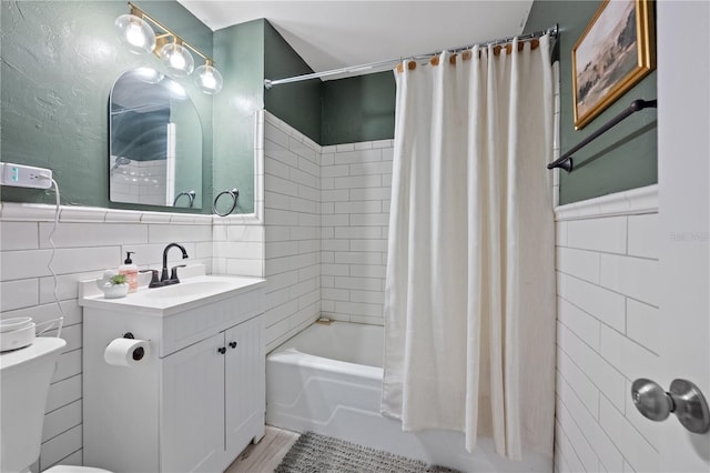219 NW 7th St, Williston, FL 32696 - full bath with wainscoting, vanity, toilet, tile walls, and shower / tub combo
