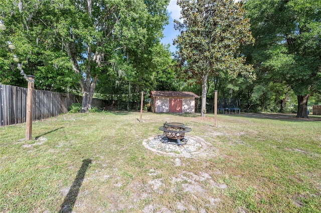 219 NW 7th St, Williston, FL 32696 - view of yard featuring fence, a trampoline, an outdoor fire pit, a storage shed, and an outdoor structure
