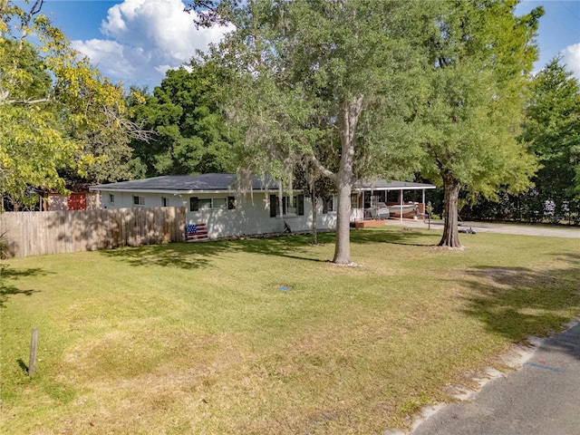 219 NW 7th St, Williston, FL 32696 - exterior space featuring fence, a carport, and a front lawn
