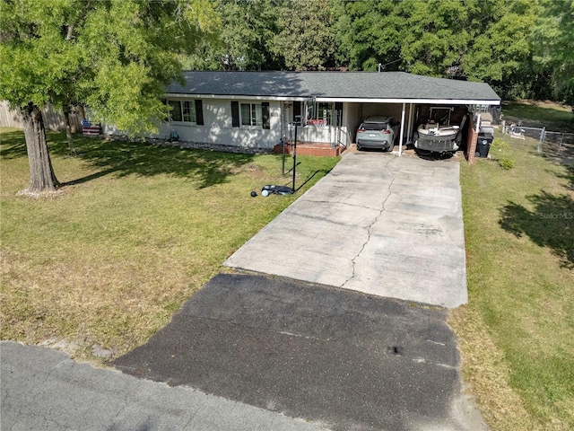 219 NW 7th St, Williston, FL 32696 - ranch-style home featuring fence, a shingled roof, a front lawn, an attached carport, and driveway