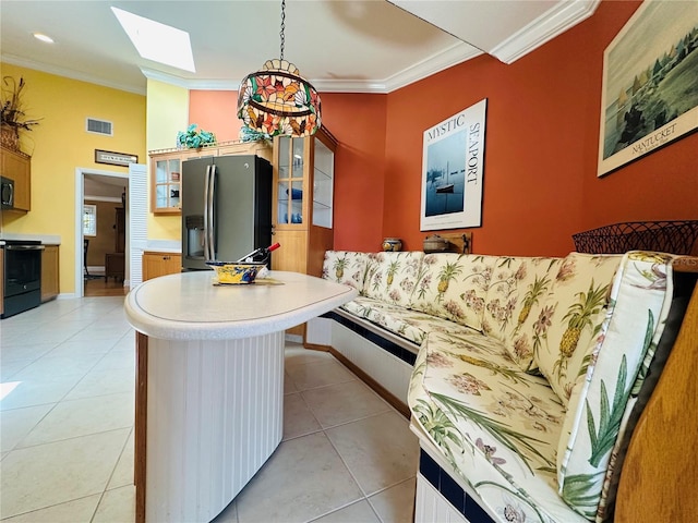 kitchen with visible vents, a skylight, light countertops, black appliances, and ornamental molding
