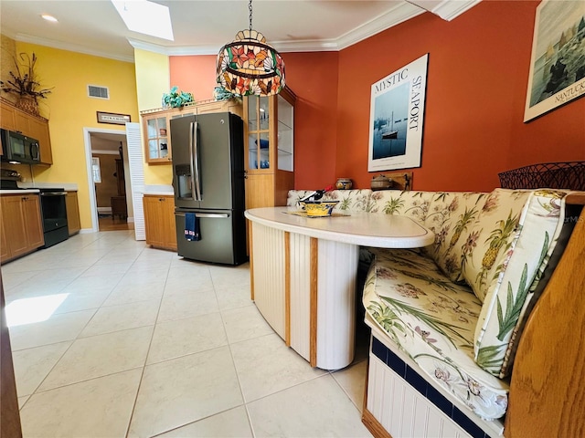 kitchen featuring visible vents, light countertops, black appliances, glass insert cabinets, and ornamental molding