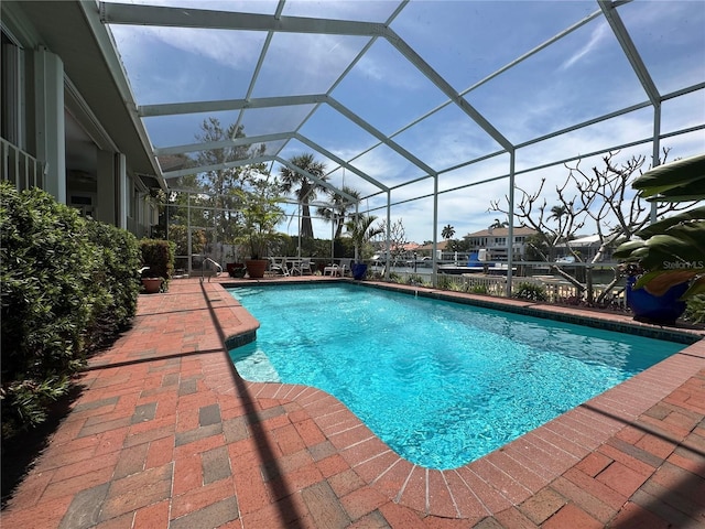 outdoor pool featuring glass enclosure and a patio area
