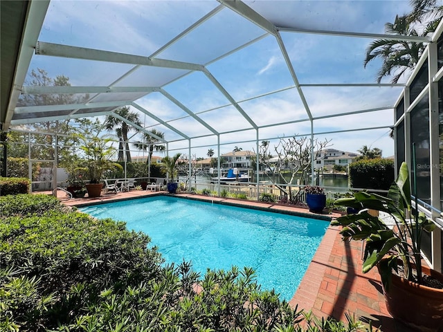 pool with a water view, a lanai, and a patio area