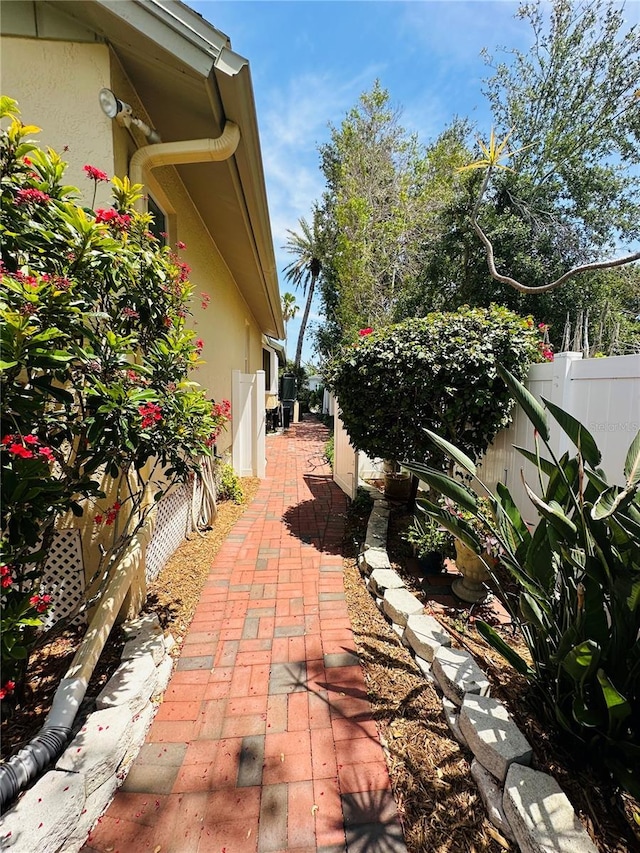 view of side of property with stucco siding and fence