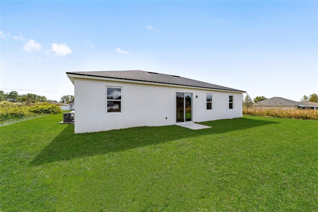 back of property with a lawn and stucco siding