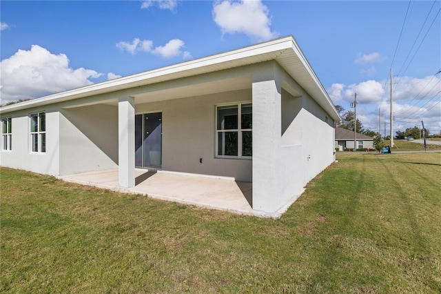 2647 SW 178th St, Ocala, FL 34473 - back of property with a patio area, stucco siding, and a lawn