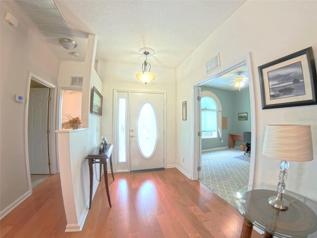 2323 NW 55th Avenue Rd, Ocala, FL 34482 - foyer featuring wood finished floors, plenty of natural light, baseboards, and a textured ceiling