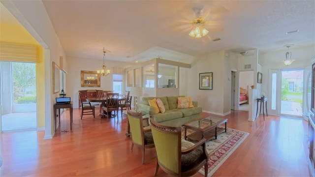 2323 NW 55th Avenue Rd, Ocala, FL 34482 - living room with healthy amount of natural light, light wood-style flooring, a chandelier, and baseboards