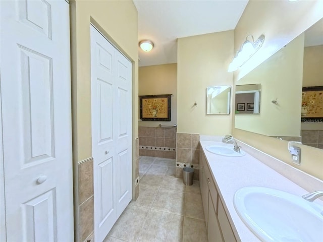 2323 NW 55th Avenue Rd, Ocala, FL 34482 - full bathroom featuring tile patterned flooring, double vanity, a wainscoted wall, a closet, and tile walls