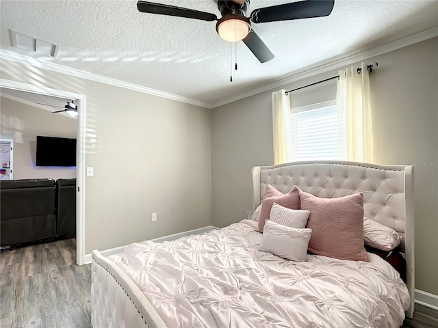 bedroom with a textured ceiling, visible vents, wood finished floors, ceiling fan, and crown molding