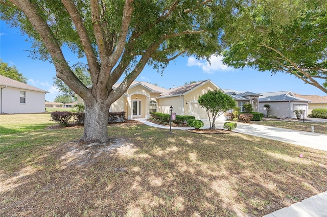 ranch-style house featuring a garage, french doors, a front lawn, and concrete driveway