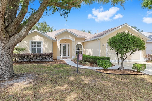 ranch-style home with an attached garage, concrete driveway, a front yard, and stucco siding