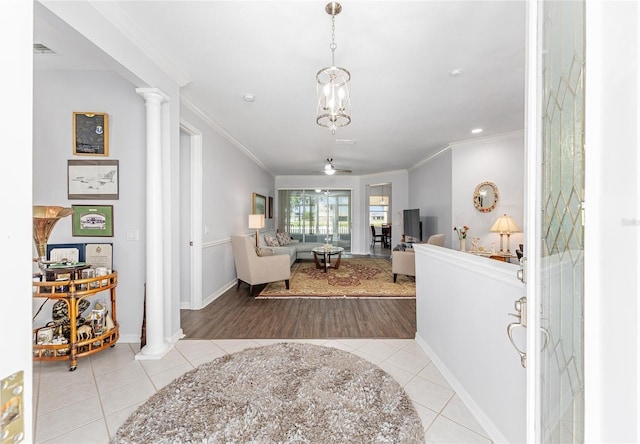 tiled foyer with a ceiling fan, baseboards, ornamental molding, and ornate columns