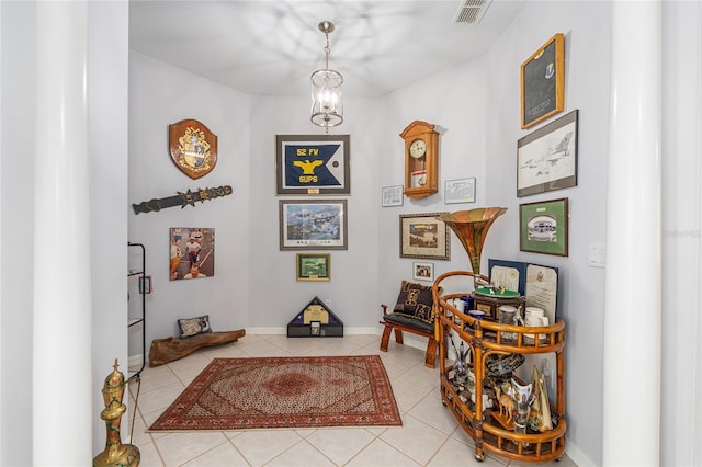 hallway featuring baseboards, visible vents, and light tile patterned floors