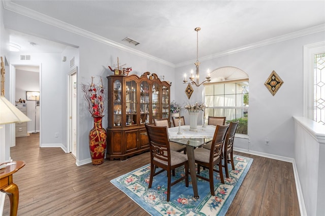 dining area featuring a notable chandelier, visible vents, ornamental molding, baseboards, and dark wood-style flooring