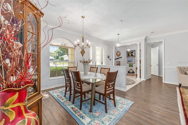 dining room with baseboards, a notable chandelier, wood finished floors, and crown molding
