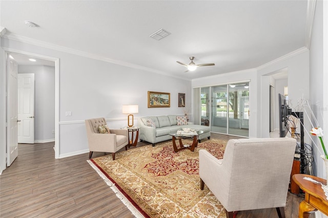 living area featuring crown molding, ceiling fan, light wood-style flooring, baseboards, and visible vents