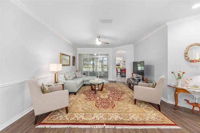 living area with wood finished floors, crown molding, and baseboards
