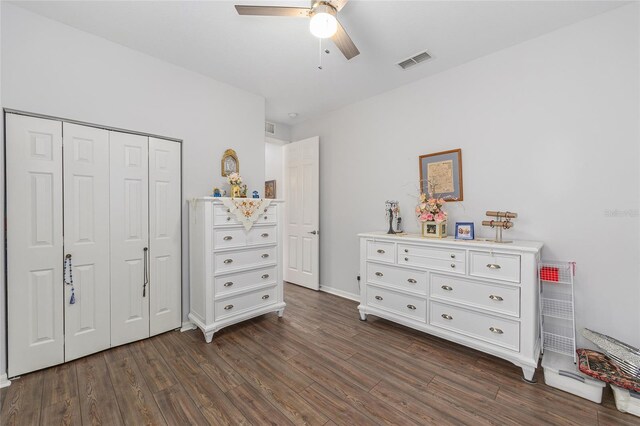 bedroom with a closet, ceiling fan, visible vents, baseboards, and dark wood-style floors