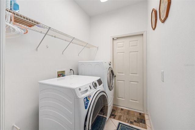 washroom with tile patterned floors, washer and dryer, and laundry area