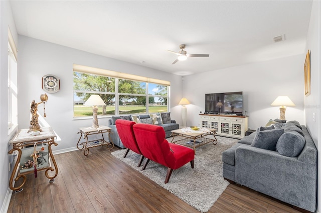 living area featuring wood-type flooring, baseboards, visible vents, and ceiling fan