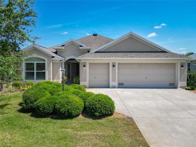 ranch-style home featuring a garage, a front yard, stucco siding, a shingled roof, and concrete driveway