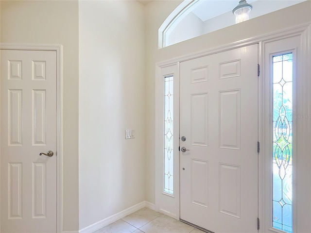 foyer featuring baseboards and light tile patterned floors