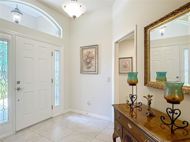 foyer entrance featuring light tile patterned flooring, baseboards, and a wealth of natural light