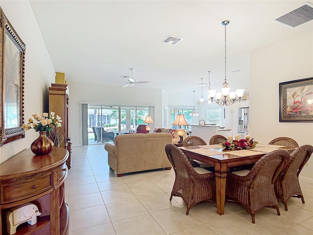 dining room with visible vents, light tile patterned floors, and ceiling fan with notable chandelier