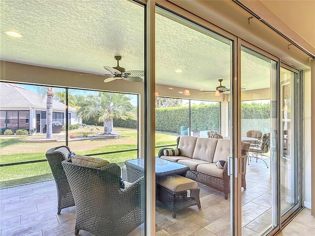 sunroom / solarium with ceiling fan and outdoor lounge area
