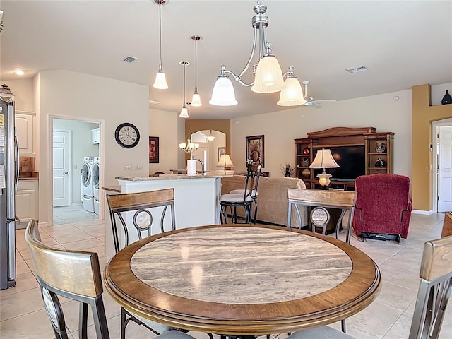 dining space featuring light tile patterned flooring, visible vents, and washing machine and dryer