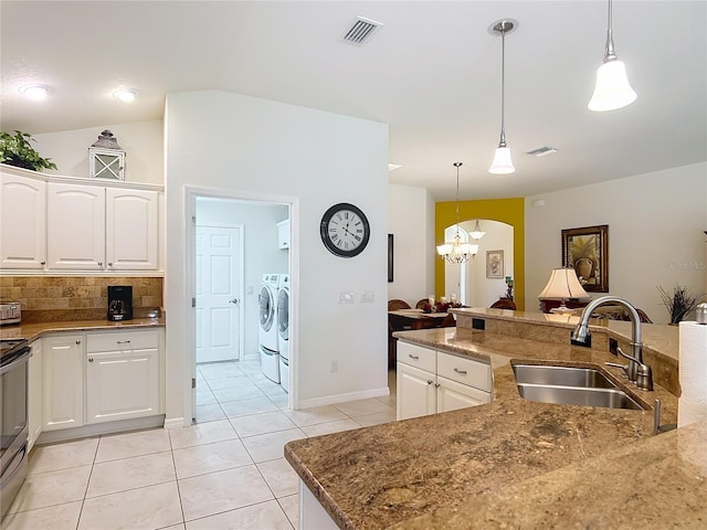 kitchen featuring decorative light fixtures, visible vents, washing machine and dryer, a sink, and a notable chandelier