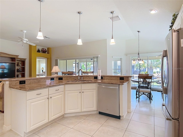 kitchen featuring a sink, appliances with stainless steel finishes, a healthy amount of sunlight, and light stone countertops