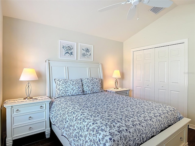 bedroom with dark wood-style flooring, ceiling fan, vaulted ceiling, visible vents, and a closet
