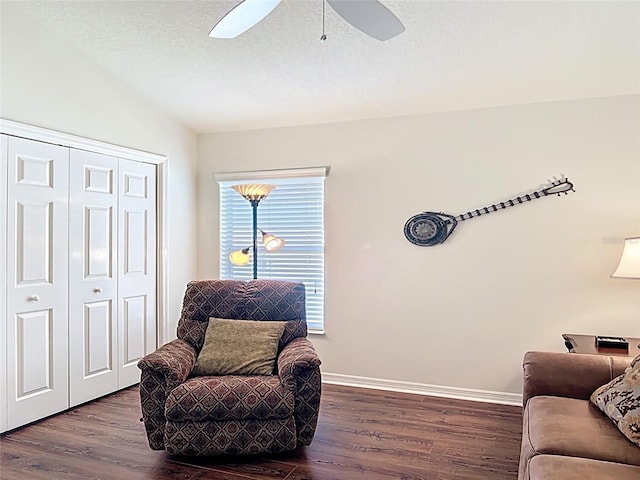 living area with dark wood-type flooring, a ceiling fan, baseboards, and lofted ceiling