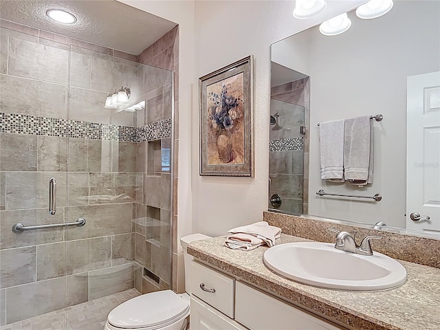 bathroom featuring vanity, toilet, and a stall shower