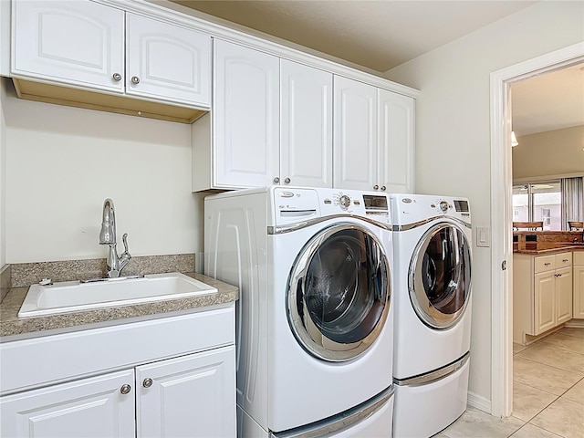 washroom featuring a sink, cabinet space, independent washer and dryer, and light tile patterned floors