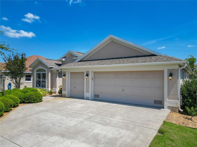 single story home with a shingled roof, an attached garage, stucco siding, and concrete driveway
